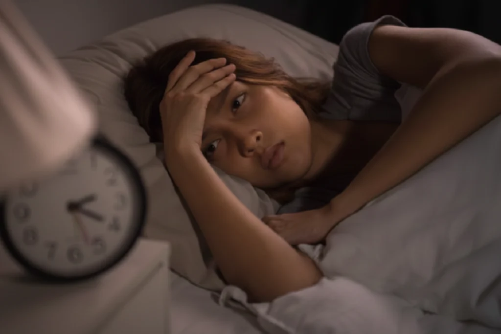 mulher com insônia deitada na cama