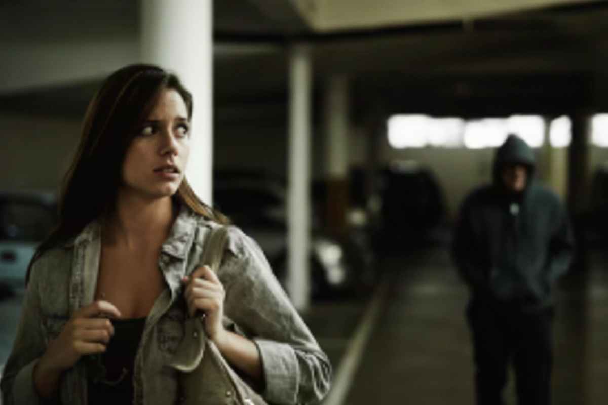 mulher sendo perseguida por uma pessoa