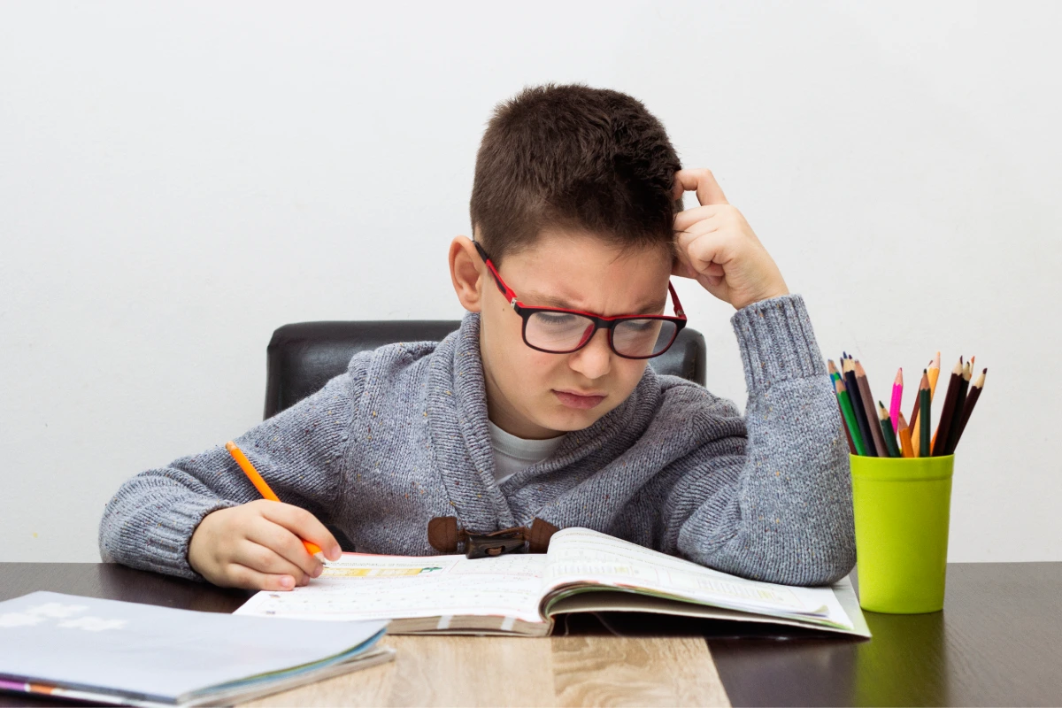 menino frustrado fazendo tarefa escolar